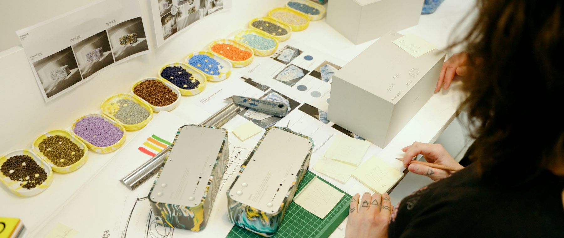 A designer working over printed material at a table