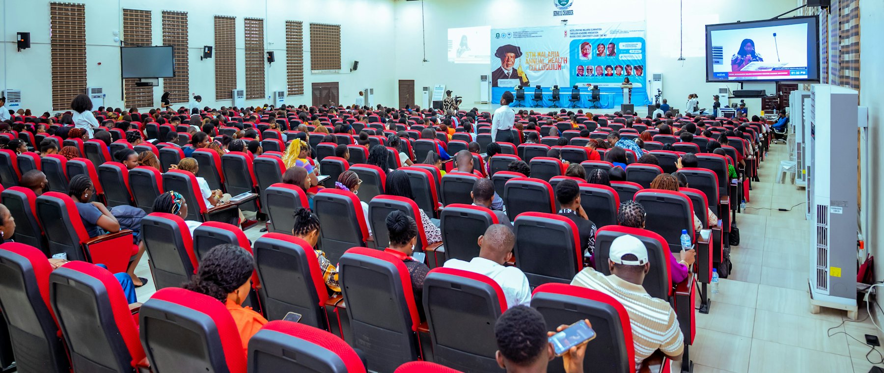 An audience seated in a large conference hall