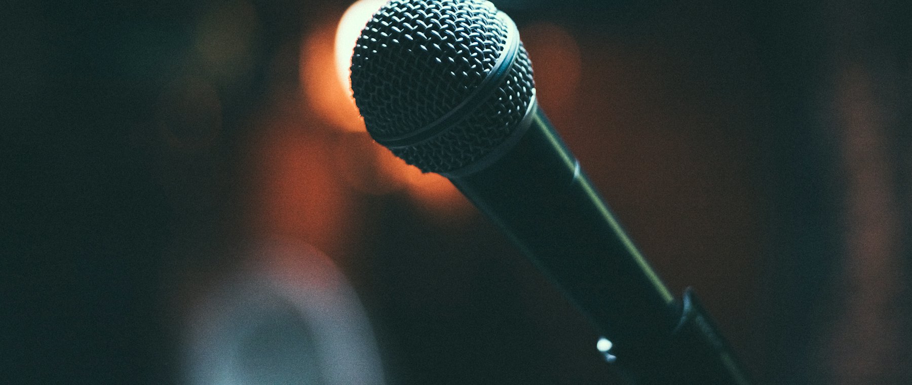 A broadcast microphone lit in a dark studio