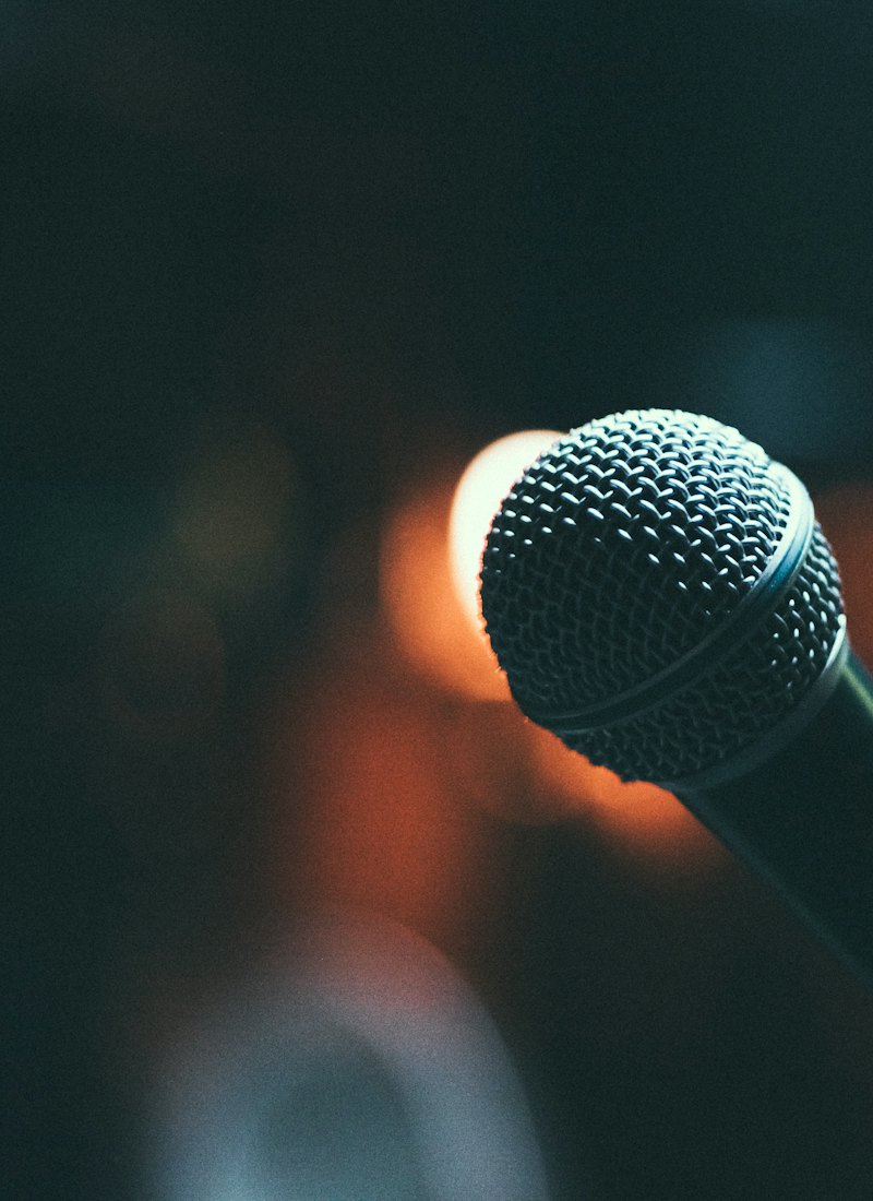 A broadcast microphone lit in a dark studio