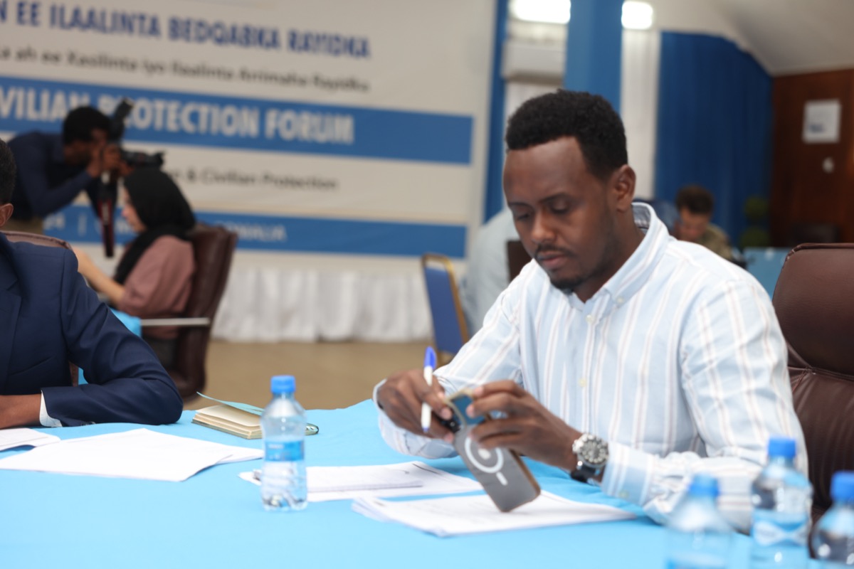 A delegate at the table, the forum branding behind