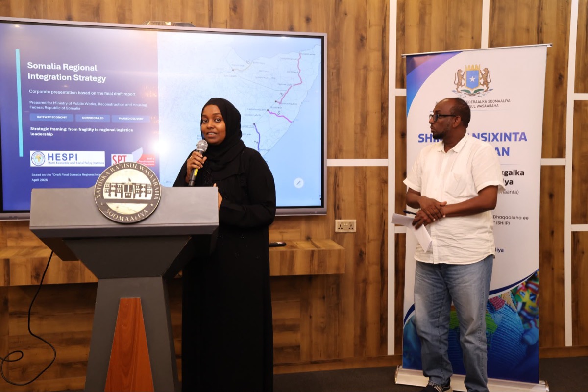A presenter at the podium beside a map of Somalia’s economic corridors